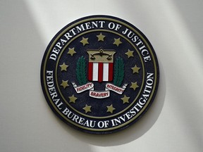 FILE - The FBI seal is pictured in Omaha, Neb., Aug. 10, 2022. A man who federal agents say tried to board a plane in New Jersey with three guns, including a semi-automatic rifle, and a fake law-enforcement ID is in federal custody and facing two charges. Seretse Clouden, who has a prior weapon-related conviction, is charged with possession of a firearm by a felon and having a fraudulent ID, according to a complaint posted Monday, Feb. 27, 2023.