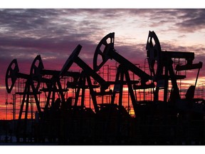 Oil pumping jacks in an oil field at sunset in Russia.