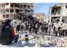 Rescue workers look for survivors amid the rubble of a building in the rebel-held town of Jindayris, Syria on February 9. Photographer: Mohammed Al-Rifai/AFP/Getty Images