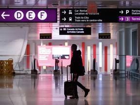 A traveller makes their way through Pearson International Airport in Toronto Monday, Nov. 14, 2022. Airlines are warning that travel in and out of Central Canada may be affected by a winter storm sweeping in from the west.THE CANADIAN PRESS/Cole Burston