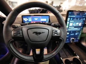 The cockpit of a Ford Mustang Mach-E electric car is pictured at the Motor Show in Essen, Germany, Thursday, Dec. 2, 2021. Automakers have made high-profile price drops for some of the most well-known electric cars this year, but experts say the overall sticker shock of buying vehicles will prove harder to remove.
