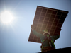 An installer carries solar panels