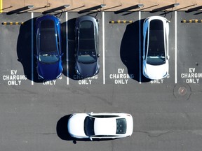In an aerial view, Tesla cars recharge at a Tesla charger station in California.