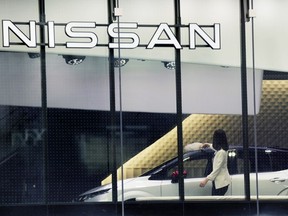 FILE - A staff of Nissan car showroom wipes a car on Jan. 31, 2022, in Tokyo. Nissan reported a 55% jump in October-December profit Thursday, Feb. 9, 2023, as the Japanese automaker seeks to embark on a less bumpy journey with its French alliance partner Renault.