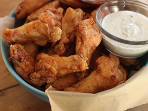 Wings with cilantro sour cream dip and honey sriracha are shown in Concord, N.H., Monday, Nov. 16, 2015. As you plan your Super Bowl spread, whether you plan to order in or cook at home, prepare for a higher price tag on your chicken wings, pizza and drinks for the big day.