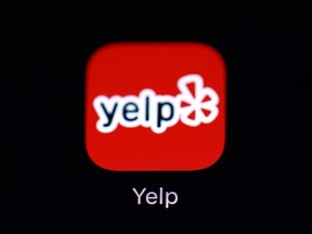 FILE- The Yelp app is seen on an iPad in Baltimore on March 19, 2018. There's been a sharp increase in the number of hate-filled business reviews spotted by Yelp's content moderators.