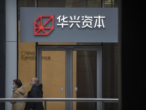 People walk past a China Renaissance office at an office building in Beijing, Feb. 17, 2023. Missing Chinese investment banker Bao Fan is co-operating with an investigation in China, his company China Renaissance said in a stock market filing Sunday, Feb. 26, 2023.