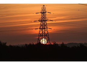 The sun rises behind an electricity transmission tower in the U.K. Photographer: Bloomberg Creative Photos/Bloomberg Creative Collection
