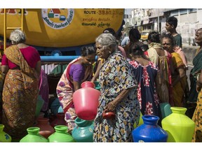 Residents wait in line to fill pots from a water truck in Chennai, India, on Wednesday, Sept. 22, 2021. Indian finance ministry officials plan to pitch for a sovereign rating upgrade from Moody's Investors Service when it meets with the firm, scheduled for Sept. 28, according to people familiar with the matter.