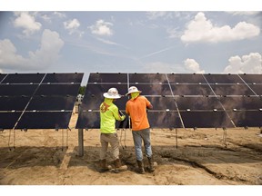 Workers install solar panels at a solar generating facility in Milligan, Tennessee.