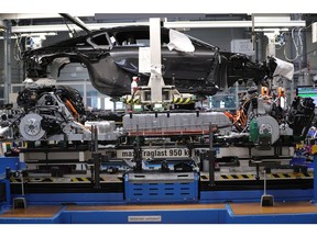 The combustion engine, left, and electric motor, right, sit on the chassis of BMW i8 hybrid electrical automobile on the body wedding assembly line at the Bayerische Motoren Werke AG factory in Leipzig, Germany, on Thursday, March 14, 2019. Chancellor Angela Merkel's plan to hatch a German battery-cell industry from scratch is gaining momentum as Europe's biggest economy tries to lower emissions while keeping Chinese automobile competition at bay. Photographer: Krisztian Bocsi/Bloomberg
