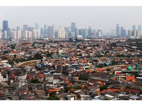 Skyscrapers are seen beyond residential buildings standing in the Jatinegara district of East Jakarta, Indonesia, on Friday, May 10, 2019. Indonesia plans to relocate its administrative capital from Jakarta, with the move set to take up to a decade and cost as much as $33 billion. Photographer: Muhammad Fadli/Bloomberg