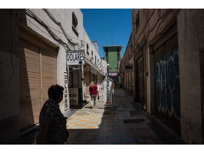 Pedestrians pass a currency exchange house in San Luis Potosi, Mexico.