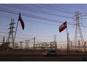 Texas flags fly near an electrical substation following a winter storm that disrupted the power grid in Houston, Texas ,on Feb. 21, 2021.