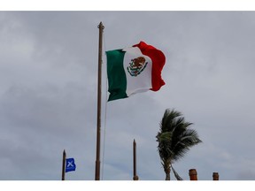 The Mexican flag flies beside a flag on the Celebrity Edge cruise ship, the first revenue-earning cruise to depart from the U.S. after a pandemic-induced hiatus, docked in Costa Maya, Mexico, on Tuesday, June 29, 2021. Celebrity Edge Cruise ship, operated under the broader Royal Caribbean Group umbrella, left the coast of Florida on June 26. Photographer: Eva Marie Uzcategui/Bloomberg