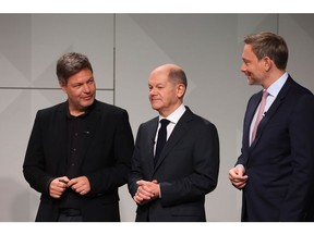 Olaf Scholz, Germany's incoming chancellor, center, Robert Habeck, co-leader of the Green Party, left, and Christian Lindner, Germany's finance minister, attend a signing ceremony of the coalition agreement to form a government in Berlin, Germany, on Tuesday, Dec. 7, 2021. Scholz cleared the final hurdle on his path to becoming German chancellor when Green Party members overwhelmingly approved their coalition deal with his center-left Social Democrats and the pro-business Free Democrats. Photographer: Liesa Johannssen-Koppitz/Bloomberg