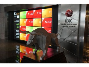 A bull statue in front of an electronic board displaying stock prices at the lobby of the Indonesia Stock Exchange (IDX) in Jakarta, Indonesia, on Monday, April 11, 2022. GoTo Group, Indonesia's biggest tech company, surged on its first day of trading after raising $1.1 billion in one of the world's largest initial public offerings this year. Photographer: Dimas Ardian/Bloomberg