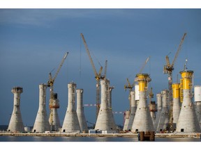 Cranes at the construction site of gravity-based wind turbine foundations for the Fecamp offshore wind farm at the Bouygues SA works in Le Havre, France, on Monday, April 11, 2022. The power generated by the Fecamp wind farm will provide enough annual electricity to meet the power needs for 770,000 people, according to Electricite de France SA.