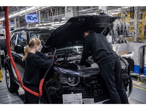 Workers install and test the battery of a Land Rover Defender sport utility vehicle (SUV) on the assembly line at the Jaguar Land Rover Plc automobile plant in Nitra, Slovakia, on Monday, Nov. 28, 2022. Jaguar Land Rover said it was looking to recruit workers who've been fired by technology companies such as Meta Platforms Inc. and Twitter Inc. to fill digital and engineering vacancies. Photographer: Akos Stiller/Bloomberg