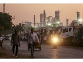 A motorcyclist rides past an oil refinery, operated by Bharat Petroleum Corp. Ltd., in Mumbai, India, on Saturday, Dec. 10, 2022. A senior official at India's oil ministry told reporters this month India has been buying oil from about 30 countries, and will continue to buy from anywhere including Russia beyond January. Photographer: Bloomberg/Bloomberg