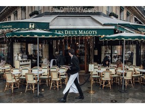 A waiter passes in front of famous "Les deux Magots" caf in Paris, France, on Monday, Jan. 2, 2023. Insee said France's inflation will continue to advance, peak in January and remain above 5% throughout the first half of the year. Photographer: Cyril Marcilhacy/Bloomberg