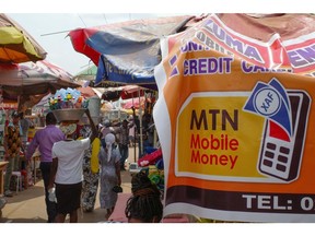 A sign advertising MTN Group Ltd. mobile money services in Accra, Ghana in January. Photographer: Nipah Dennis/Bloomberg