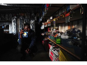 A worker uses a torch inside a hardware store during loadshedding, in Johannesburg, South Africa.