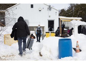 Migrants enter Canada at an informal border crossing in Champlain, New York, US, on Sunday, March 5, 2023. Ahead of US President Joe Biden's visit to Canada later this month, Quebec Premier Francois Legault is trying to draw attention to the hundreds of migrants a day coming via a remote dirt path, known as Roxham Road, at the New York border about 40 miles south of Montreal.
