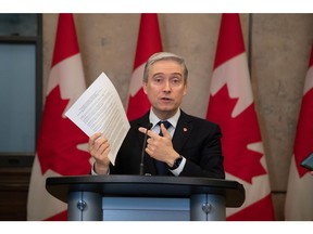 Francois-Philippe Champagne, Canada's innovation, science and industry minister, holds documents related to Rogers Communications during a news conference on competitiveness in the telecommunications sector on Parliament Hill in Ottawa, Ontario, Canada, on Friday, March 31, 2023. The Canadian government will allow Rogers Communications Inc. to acquire rival Shaw Communications Inc., ending a two-year odyssey to seal one of the biggest corporate takeovers in the country's history.
