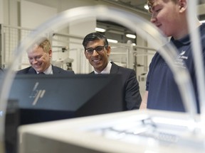 Britain's Prime Minister Rishi Sunak, centre and Grant Shapps, Secretary of State for Energy Security and Net Zero, left, are shown robotics by an apprentice, during a visit to the UK Atomic Energy Authority, Culham Science Centre, for a discussion on energy security and net zero, in Abingdon, England, Thursday March 30, 2023.