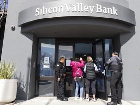 Security guards let individuals enter the Silicon Valley Bank's headquarters in Santa Clara, Calif., on Monday, March 13, 2023. The federal government intervened Sunday to secure funds for depositors to withdraw from Silicon Valley Bank after the banks collapse. Dozens of individuals waited in line outside the bank to withdraw funds.