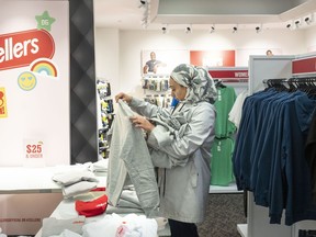 A shopper picks up an item at a newly-opened Zellers store in Scarborough Town Centre Mall, in Scarborough, Ont., on Thursday March 23, 2023.
