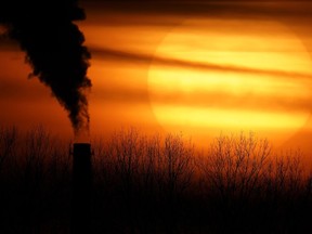 FILE - Emissions from a coal-fired power plant are silhouetted against the setting sun in Kansas City, Mo., Feb. 1, 2021. A closely watched rule from the Securities and Exchange Commission that would require public companies to say much more to shareholders about how their operations affect the climate has generated more public comment than many recent regulations from the agency, attorneys and industry experts say.