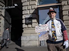 A local pensioner protests in front of the Credit Suisse headquarters in Zurich on Monday after UBS agreed to take over its troubled Swiss rival. Shares in European banks sank despite the rescue aimed at preventing a global banking crisis.