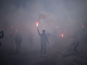 Protesters march with flares during a demonstration in Marseille, southern France, Tuesday, March 28, 2023. France's government is unfurling massively ramped-up security measures for a fresh blast of marches and strikes against unpopular pension reforms.