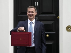 Britain's Chancellor of the Exchequer Jeremy Hunt poses for the media with his traditional Red ministerial box as he leaves 11 Downing Street for the House of Commons to deliver the Budget in London, Wednesday, March 15, 2023.