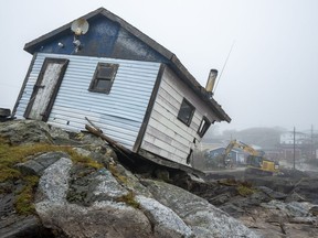 Workers start to clean up the devastation left by Hurricane Fiona in Burnt Island, N.L. on Wednesday Sept. 28, 2022. The federal government committed $31.7 million over three years in its latest budget to a low-cost flood insurance program. THE&ampnbsp;CANADIAN PRESS/Frank Gunn