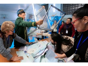 Members of a local electoral commission empty a ballot box at a polling station after parliamentary elections in Almaty on March 19, 2023.  Photographer: Ruslan Pryanikov/AFP/Getty Images