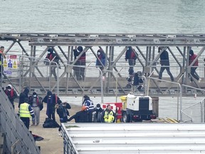 A group of people thought to be migrants are brought in to Dover, Kent, onboard a Border Force vessel following a small boat incident in the Channel, England, Monday March 6, 2023. The British government said Monday it will introduce legislation to ban anyone who arrives in the U.K. in small boats across the English Channel from ever settling in the country.