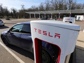 A driver recharges the battery of his Tesla Inc. car in a petrol station on the highway in Chateauvillain, France.