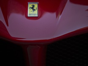 The Ferrari logo on the hood of a 488 GTB sports vehicle parked outside of the New York Stock Exchange.