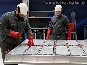 Volkswagen employees disconnect old battery systems from all their parts in a battery recycling plant in a pilot line for battery cell production.