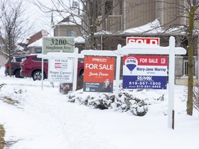 For sale signs in front of three homes on Springmeadow Road in London, Ont.