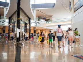 A family walks inside Sherway Gardens mall in Toronto.