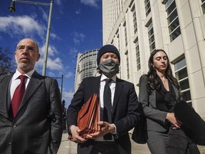 Roger Ng, center, a former Goldman Sachs banker, leaves federal court with his lawyers Zach Intrater, left, and Tiny Geragos, right, after being sentenced to 10 years in prison for his role in looting a Malaysian development fund, Thursday March 9, 2023, in New York.