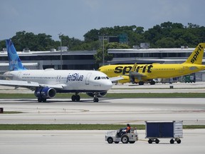 FILE - A JetBlue Airways Airbus A320, left, passes a Spirit Airlines Airbus A320 as it taxis on the runway, July 7, 2022, at the Fort Lauderdale-Hollywood International Airport in Fort Lauderdale, Fla. The Biden administration wants to block JetBlue from buying Spirit Airlines, saying the deal would reduce competition and hurt travelers.