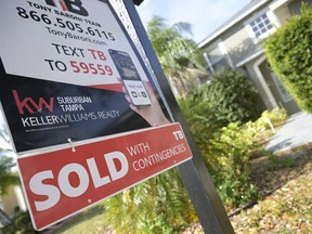 A real estate sign is posted outside of a recently sold home, Tuesday, Feb. 21, 2023, in Valrico, Fla. On Tuesday,
