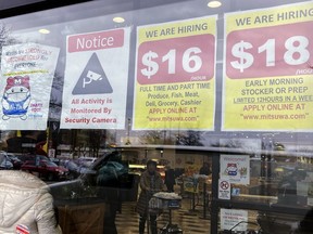 FILE - Hiring signs are displayed at a grocery store in Arlington Heights, Ill., Jan. 13, 2023. Employers are increasingly posting salary ranges for job openings, even in states where it's not mandated by law, according to analysts with employment sites Indeed, GlassDoor, and Monster.