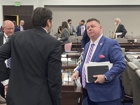 FILE - North Carolina state Rep. Jason Saine, R-Lincoln, at right, speaks with Rep. Terence Everitt, D-Wake, after a House Commerce Committee at the Legislative Office Building on Tuesday, March, 21, 2023, in Raleigh, N.C. Sports gambling in North Carolina soared over a major hurdle on the track to its ultimate authorization on Tuesday, March 28, as the House voted for legislation to permit, regulate and tax wagering activities less than a year after the chamber scuttled a similar effort. Saine is a chief sponsor of a sports gambling measure that received initial approval in the state House on Tuesday.