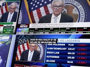Displays show Fed chairman Jerome Powell's news conference while traders work on the floor at the New York Stock Exchange in New York, Wednesday, March 22, 2023.
